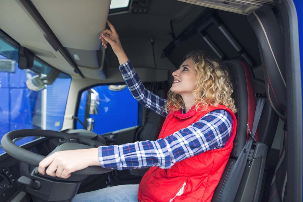 Woman driving a lorry checking at a sat nav screen